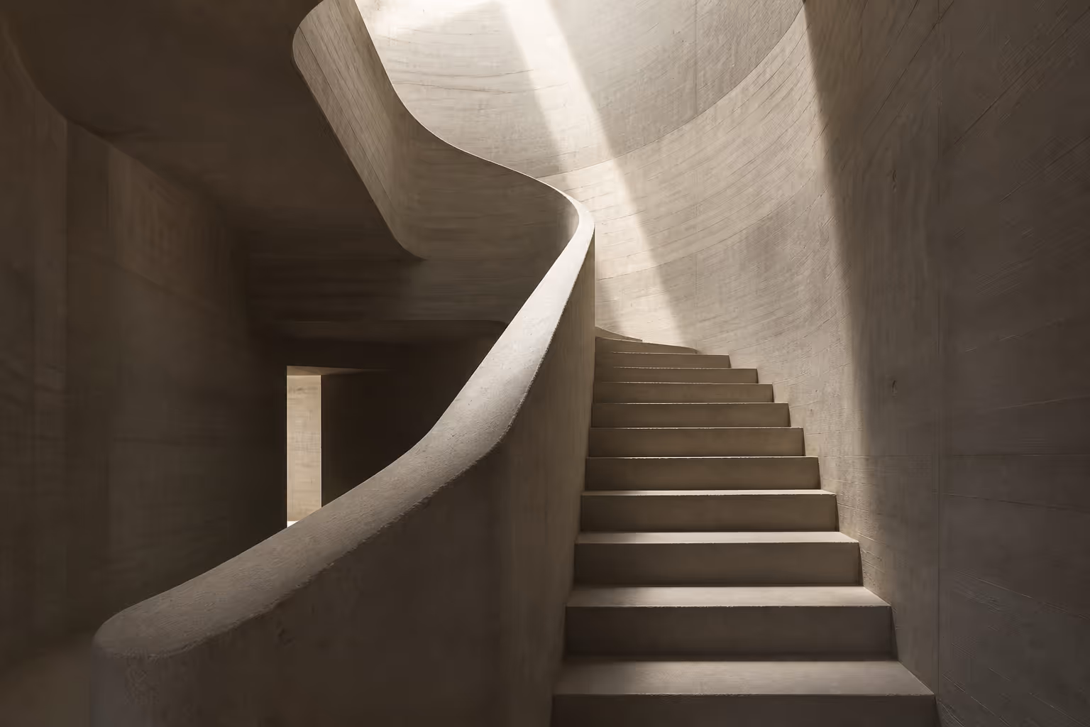 Modern sculptural concrete staircase lit dramatically by daylight from above