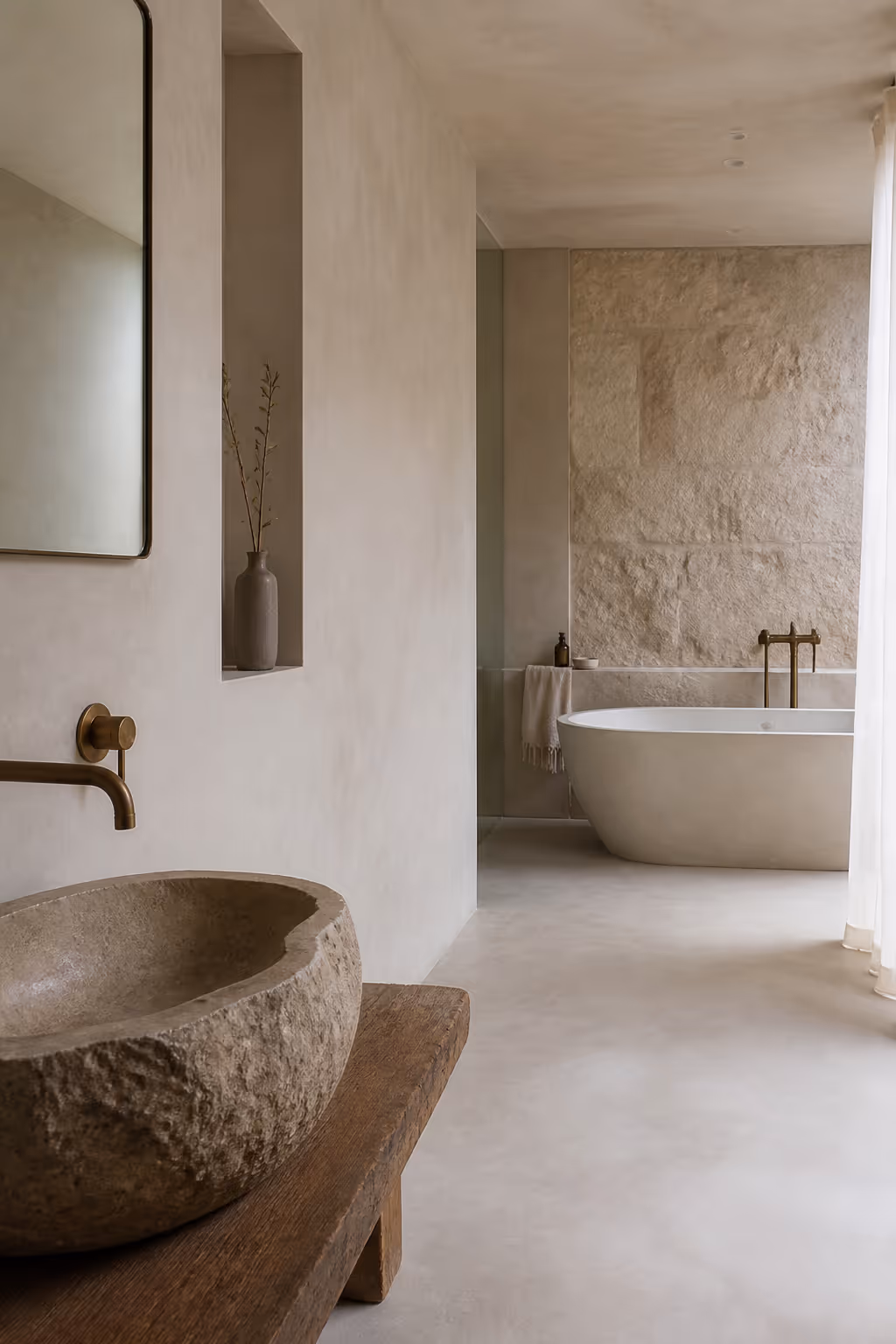 Spa-like bathroom finished in microcement and stone under soft diffused light